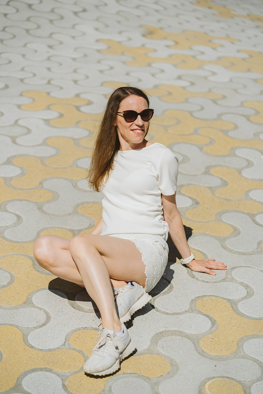 Sonja Rajala sitting on patterned paving in the sun